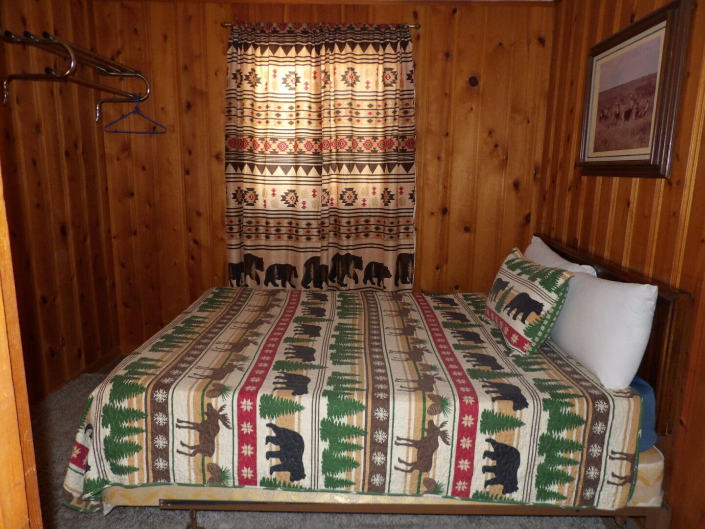 A bed with a bear and moose print on it.