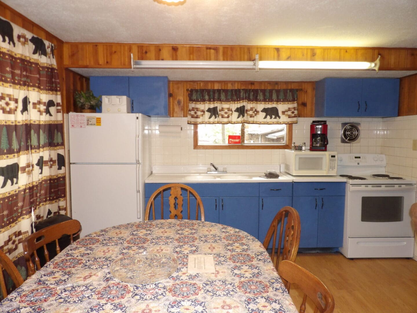 A kitchen with blue cabinets and white appliances.