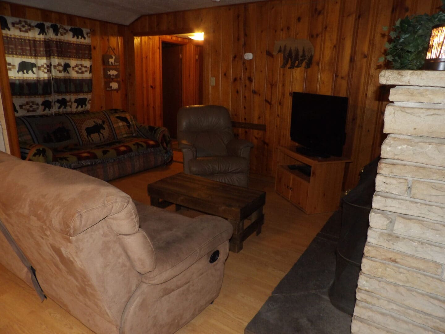 A living room with wood paneled walls and furniture.