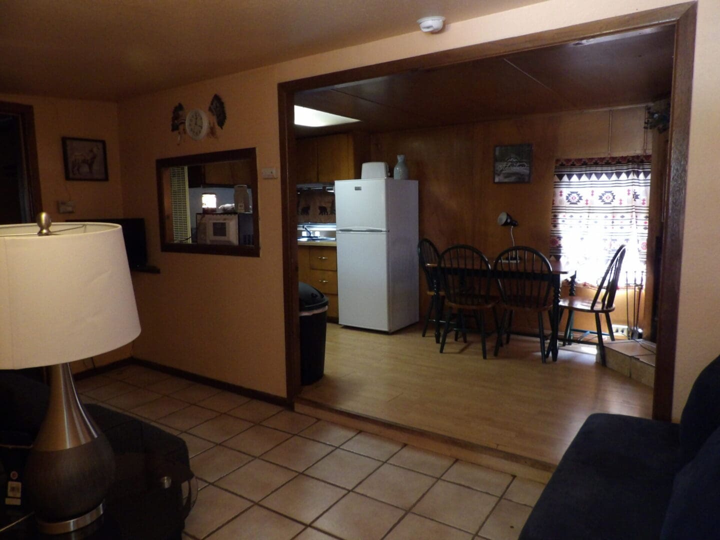 A kitchen with a refrigerator, microwave and table.
