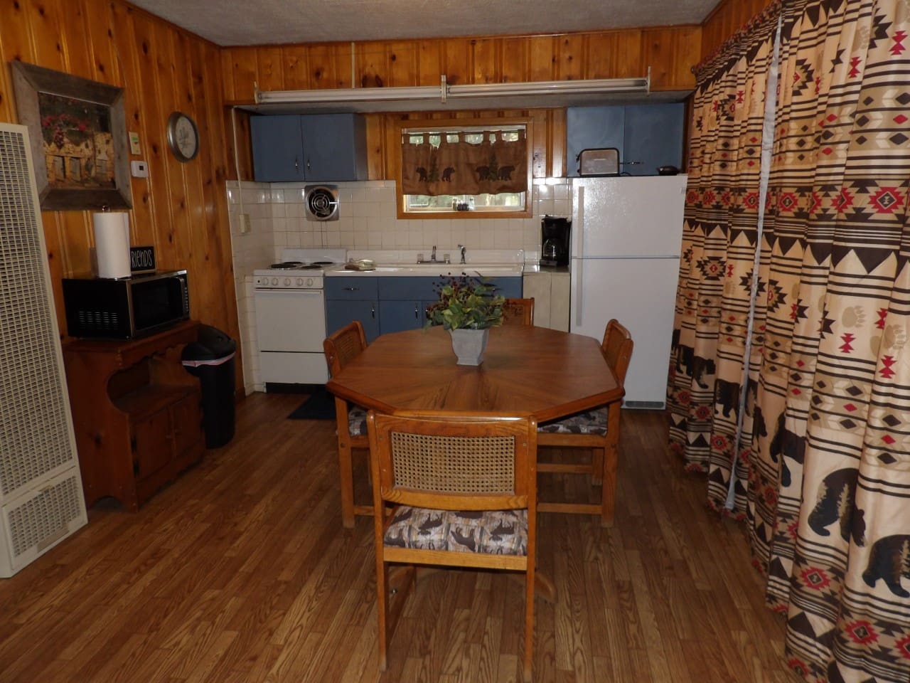 A kitchen with wood floors and wooden cabinets.