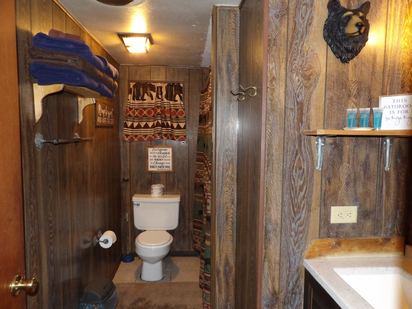 A bathroom with wood paneling and a toilet.