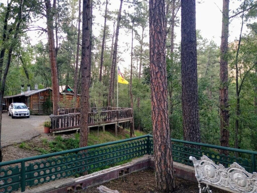 A goat statue in the middle of a forest.